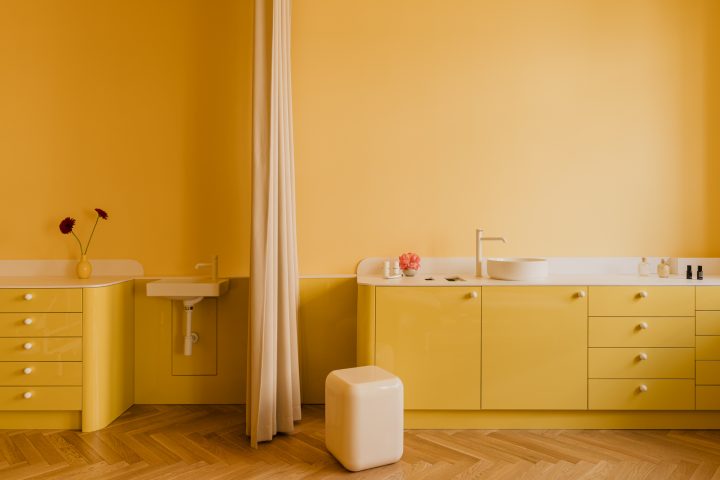Żółty gabinet z zabudową, umywalką i zasłoną