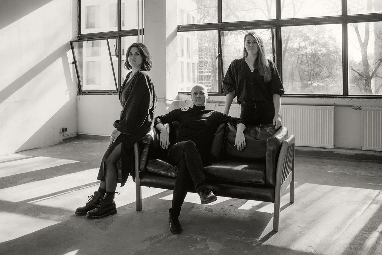 Zespół MUM Studio na skórzanej sofie w jasnym wnętrzu z dużymi oknami